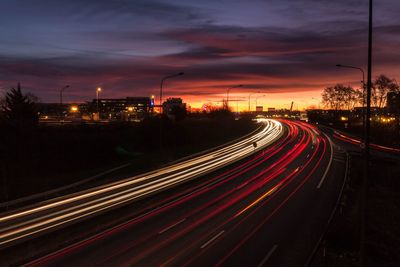 Light trails on road against sky during sunset