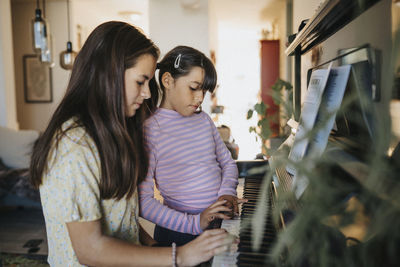 Sisters bonding over playing piano together