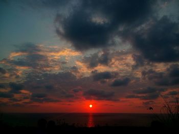 Scenic view of sea against cloudy sky during sunset