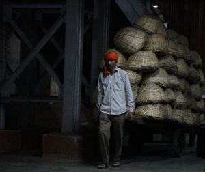 Man pulling cart with stack of wicker baskets at chhatrapati shivaji terminus