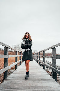 Portrait of young woman standing on bridge