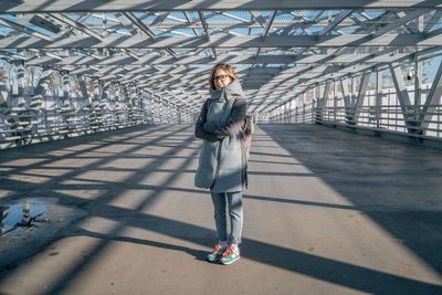 Full length of woman standing on footbridge