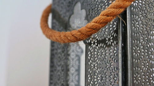 Close-up of metal hanging on rope
