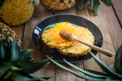 High angle view of pineapples with honey on table