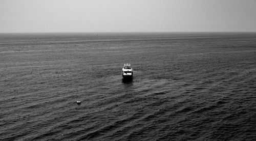 Boat sailing in sea against clear sky