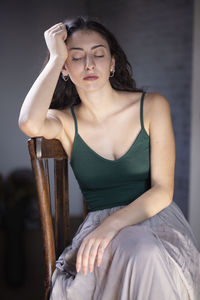 Young woman looking away while sitting on seat