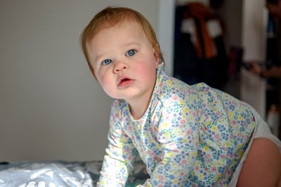 Cute girl of ten months old, playing alone in a crib at home in the afternoon or in the morning.