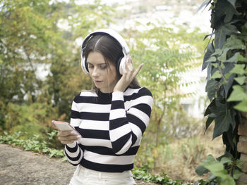 Young woman standing against trees