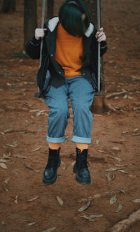 Woman sitting on swing at playground