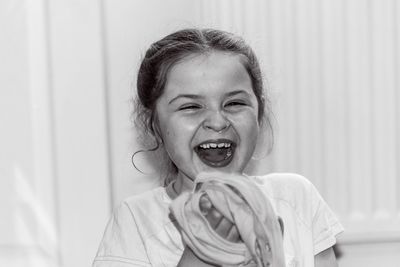 Close-up portrait of girl laughing by curtain