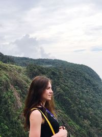 Side view of woman standing against mountains