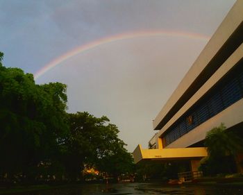 Rainbow over city against sky