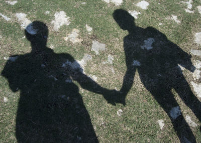 High angle view of father with shadow on hands