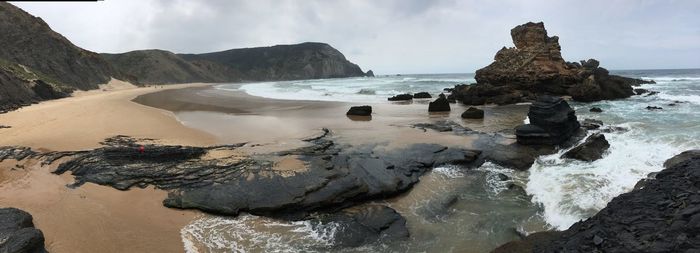 Panoramic view of rocks on beach against sky