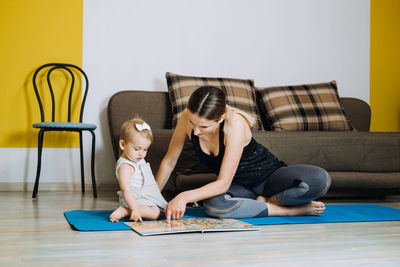 Learning activities for toddlers baby. mother reading book with cute toddler baby daughter