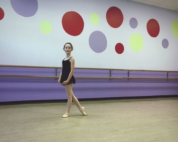 Full length of girl practicing ballet at studio 