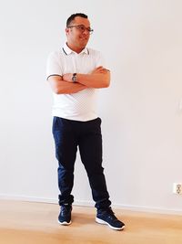 Portrait of young man standing against wall