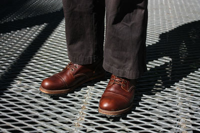 Low section of man standing on tiled floor