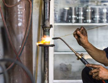 Midsection of man holding burning candles