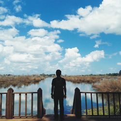 Rear view of woman standing on jetty