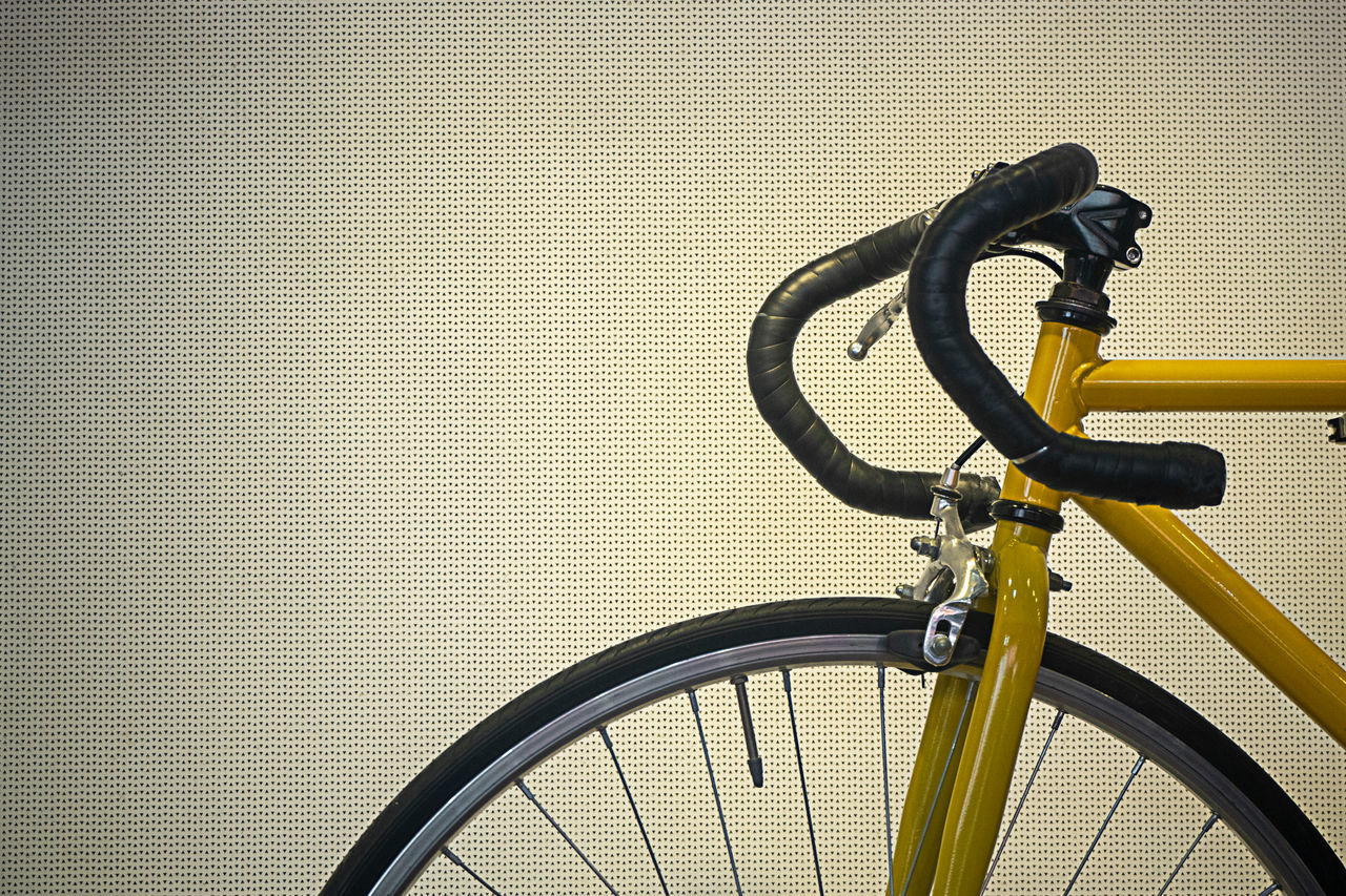 CLOSE-UP OF BICYCLE ON METAL WALL