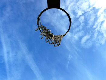 Directly below shot of basketball hoop against blue sky