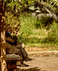 Side view of a man sitting on seat