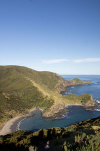 Scenic view of sea and mountains against blue sky