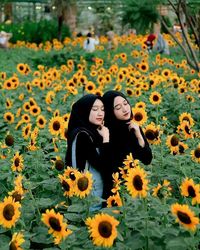 Woman and yellow flowering plants on field