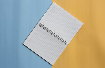High angle view of open book on table against blue background