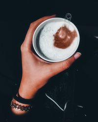 Cropped hand of woman holding coffee cup