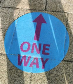 Close-up of arrow sign on road