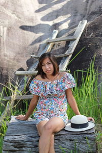 Portrait of a smiling young woman sitting outdoors