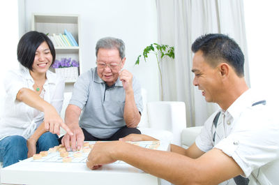 Happy family playing board game at home