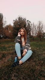 Portrait of young woman sitting on field