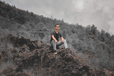 Young man sitting on rock