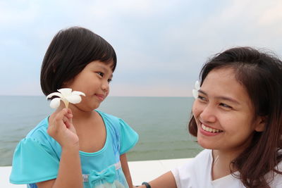 Portrait of smiling woman against sea against sky