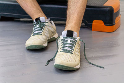 Close-up of men's legs in sneakers with green laces. 