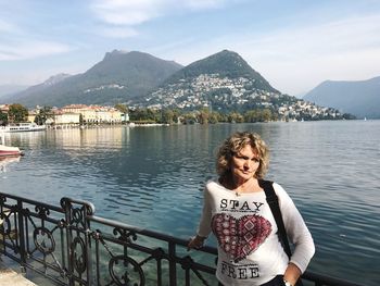 Woman standing by lake in town