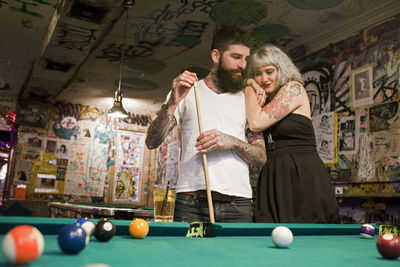 Young couple playing pool