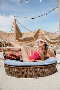 Midsection of woman lying on floor against sky