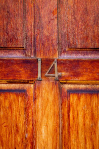 House number 14 on a varnished wooden front door in london 