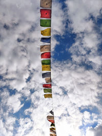 Low angle view of flags against cloudy sky