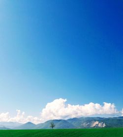 Low angle view of landscape against blue sky