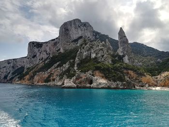 Scenic view of sea by rock formation against sky