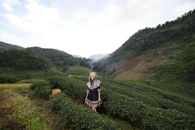Woman standing on mountain against sky