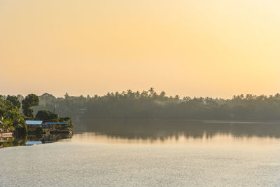 Scenic view of lake against clear sky during sunset