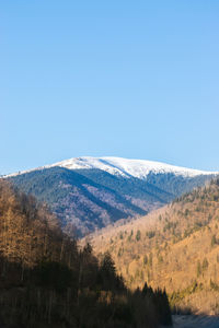 Scenic view of snowcapped mountains against clear blue sky