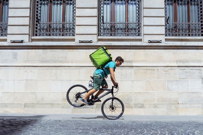 Young man performing stunt while riding bicycle on street