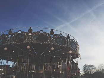 Low angle view of illuminated amusement park against sky